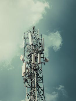 A tall communication tower stands against a moody, cloudy sky, showcasing modern technology.