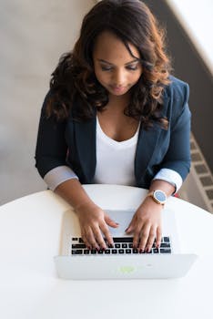 Young woman working remotely indoors on a laptop, emphasizing technology and productivity.